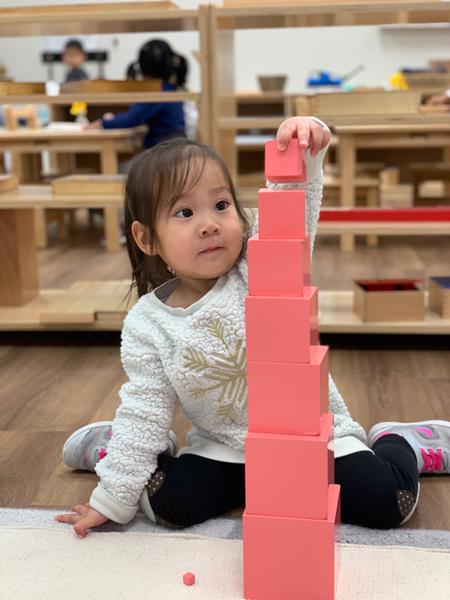 Student works on pink tower traditional montessori Frisco, TX Guidepost at Stonebriar